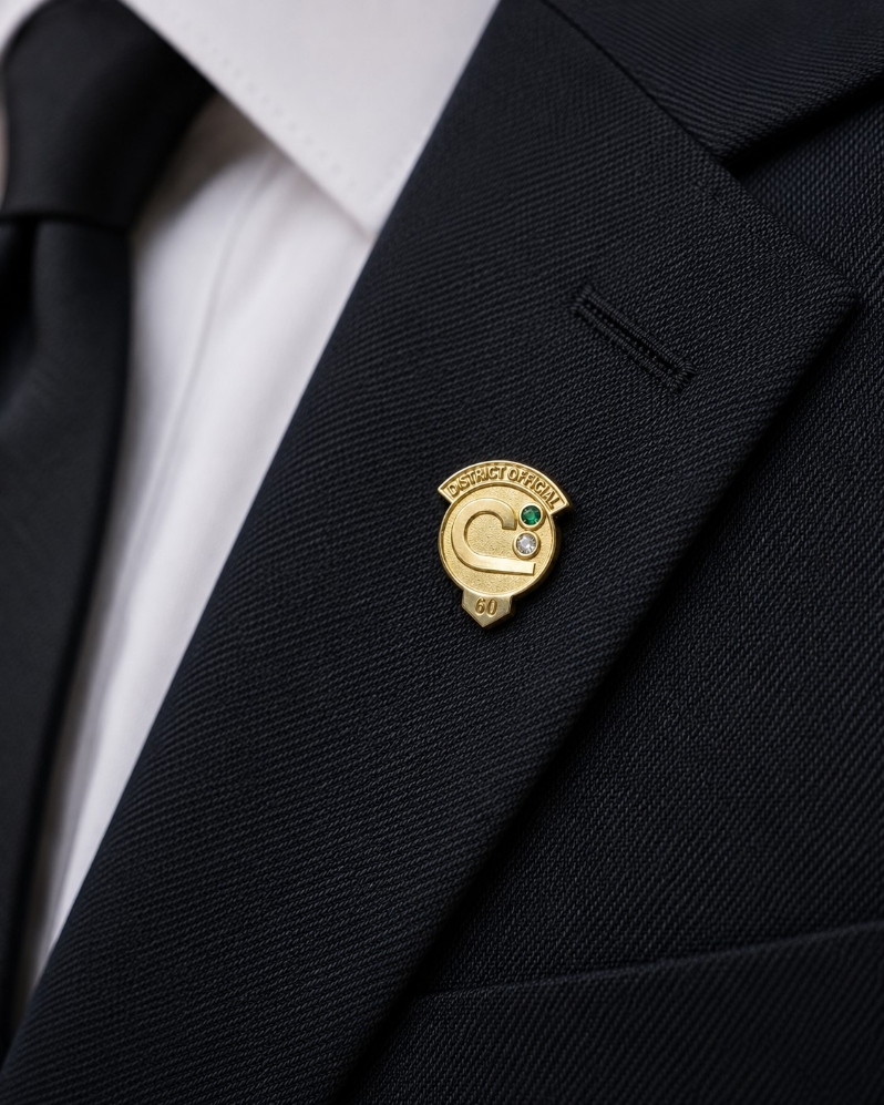Product Description: District Official Longevity Pins</br></br>Recognize years of dedicated service with NACD's District Official Longevity Pins. Available in five year increments from 5 through 60 years, these polished brass pins honor the commitment and leadership of conservation district officials.</br></br>Each pin features the NACD Conservation C, the applicable years of service, and genuine faceted gemstones selected for each milestone. Designed for professional wear, the pin is sized to complement a suit jacket, blazer, or dress attire and includes a secure clutch back.</br></br>Ideal for annual meetings, board recognition, employee appreciation, and special award presentations, these custom crafted pins provide a meaningful way to celebrate service to conservation districts and the communities they serve.</br></br>Features</br></br>Polished brass finish</br>Genuine faceted gemstones</br>Available in 5 year increments from 5 through 60 years</br>Secure clutch back</br>Approximately 3/4 inch tall</br>Individually packaged for presentation</br></br>A timeless recognition of dedication, leadership, and service to conservation.</br> District Official Pin - 60 years